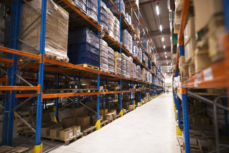 Interior Of Large Distribution Warehouse With Shelves Stacked With Palettes And Goods Ready For The Market. - Contabilidade em Campos Elíseos | Venegas Contábil